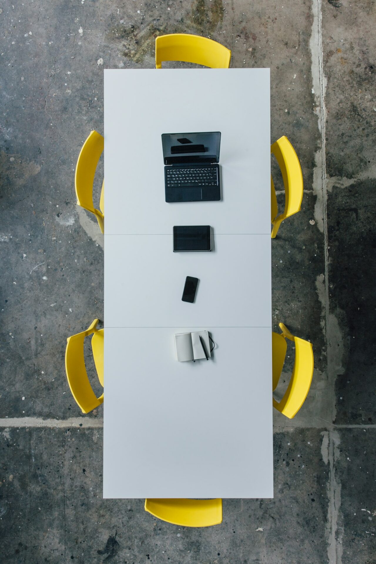Conference table seen from above, tablet, smartphone, laptop and notebook